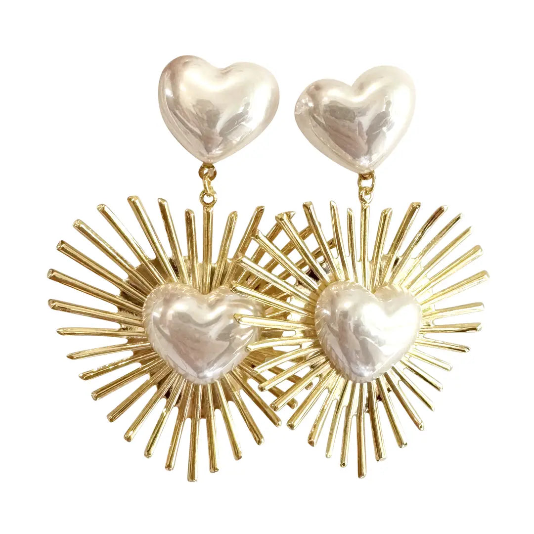 Heart-shaped earrings with gold sunburst designs on a white background
