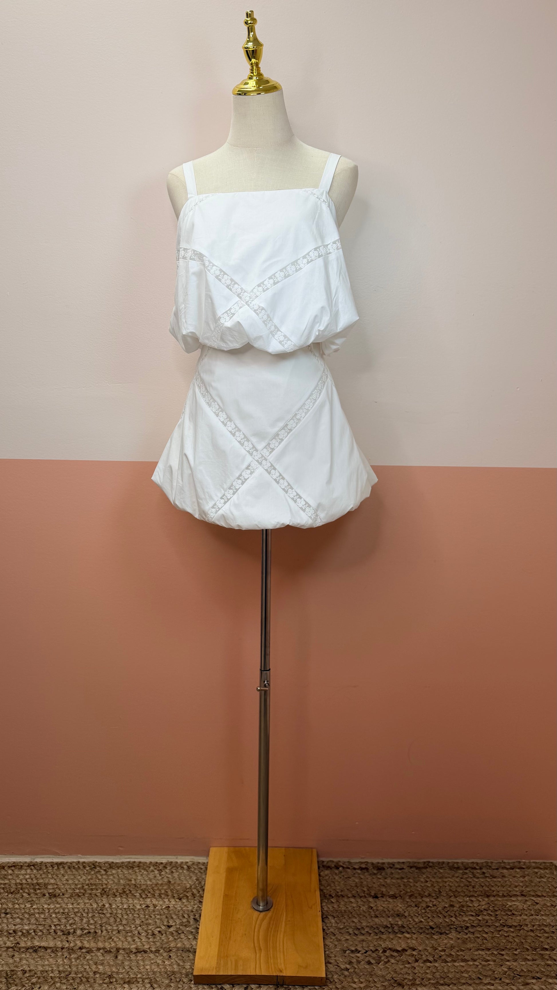 Dylan Sleeveless Bubble Hem Crop Top with Lace Trim and Bubble Skirt Set - The Spark Boutique White lace top and skirt set on a mannequin against a plain background.Bubble hem crop top with delicate lace trim neckline detail. The Spark Boutique| West Palm Beach