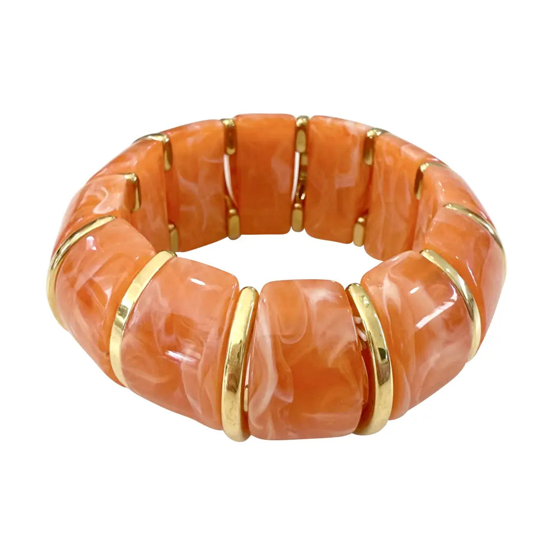 Orange bracelet with gold accents on a white background
