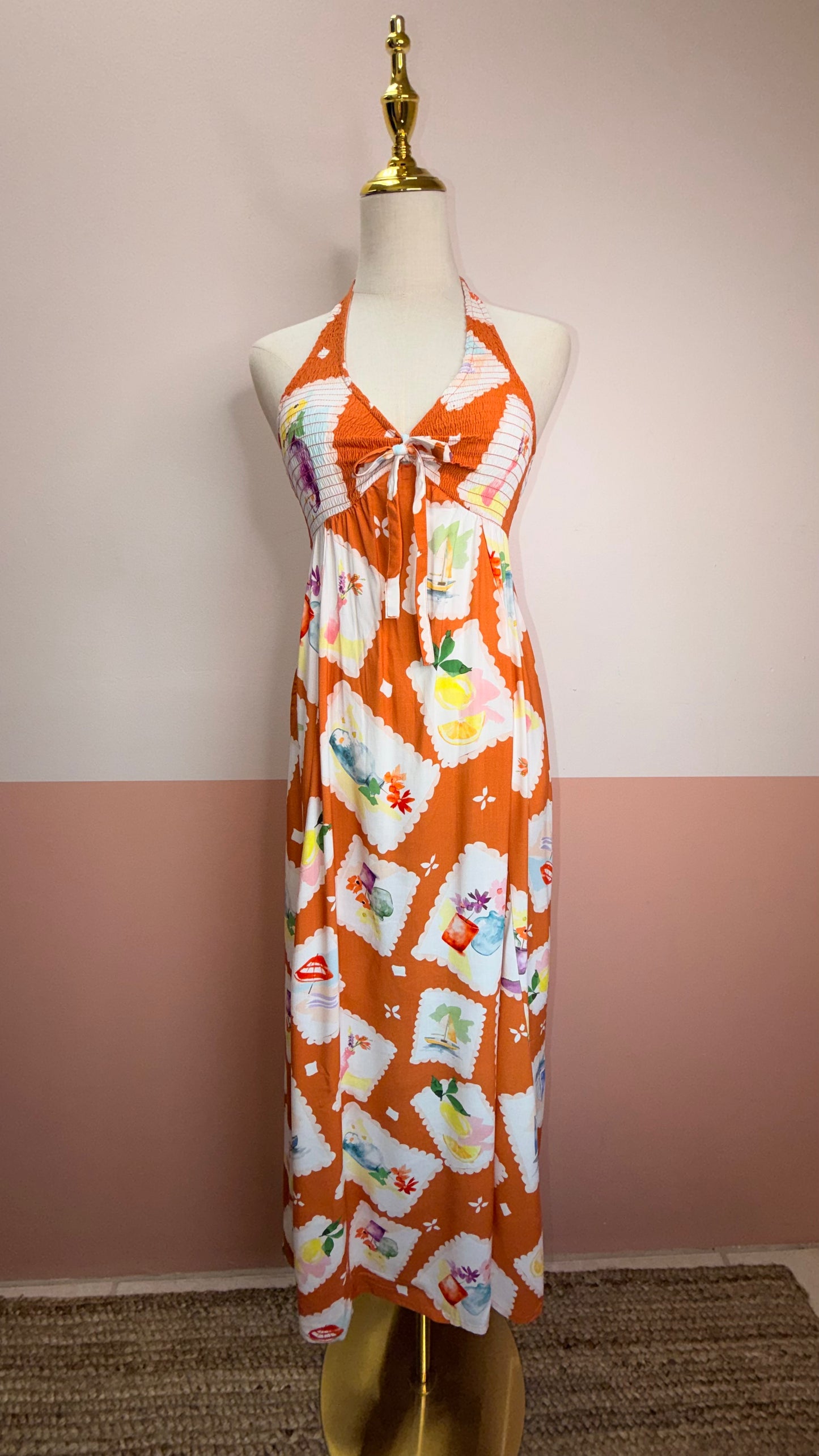 Vibrant printed halter dress with smocked bodice and colorful pattern. 