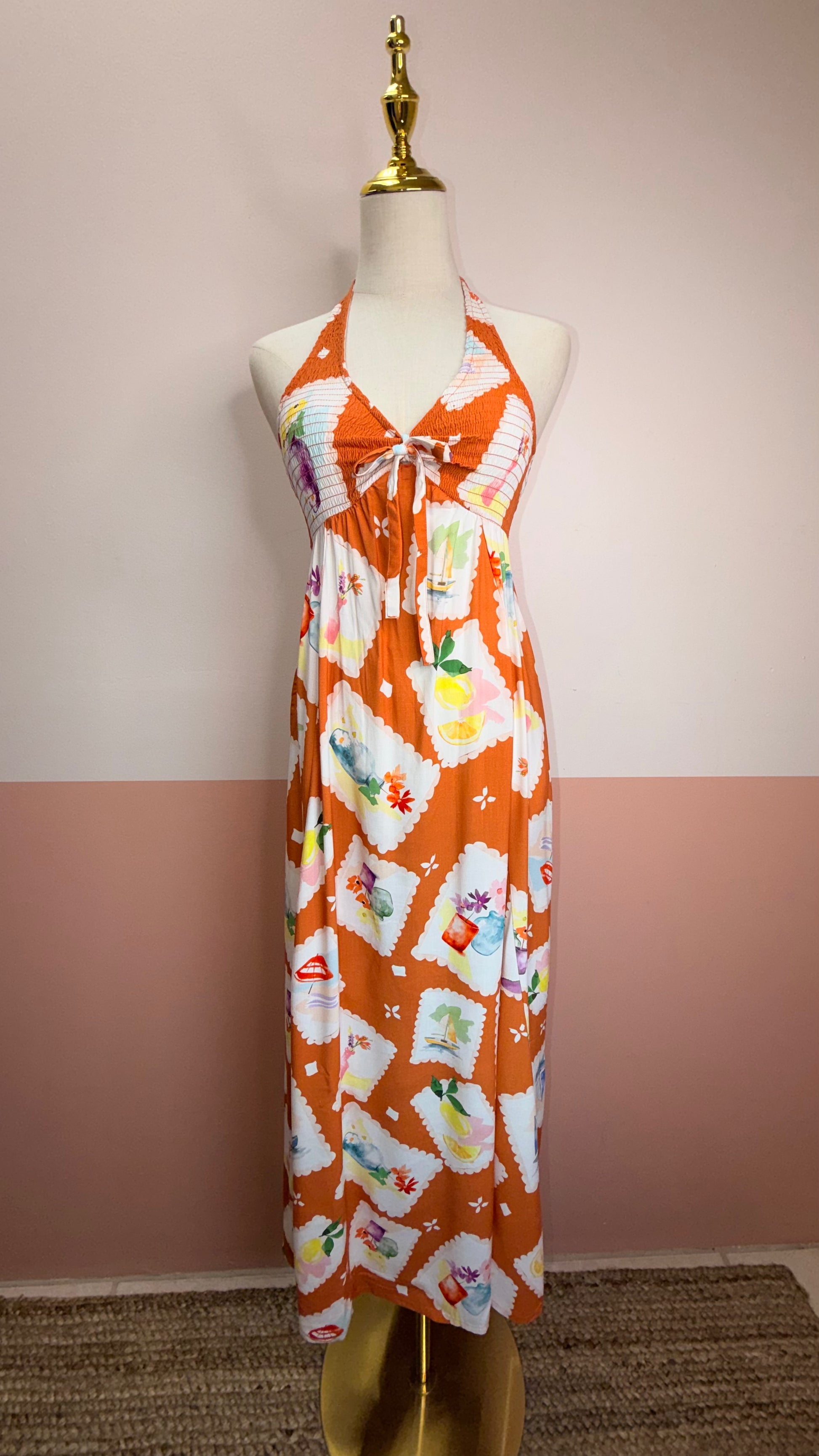 Vibrant printed halter dress with smocked bodice and colorful pattern. 