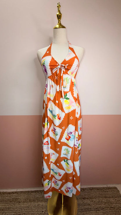 Vibrant printed halter dress with smocked bodice and colorful pattern. 