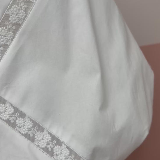 White lace top and skirt set on a mannequin against a plain background.Bubble hem crop top with delicate lace trim neckline detail. The Spark Boutique| West Palm Beach